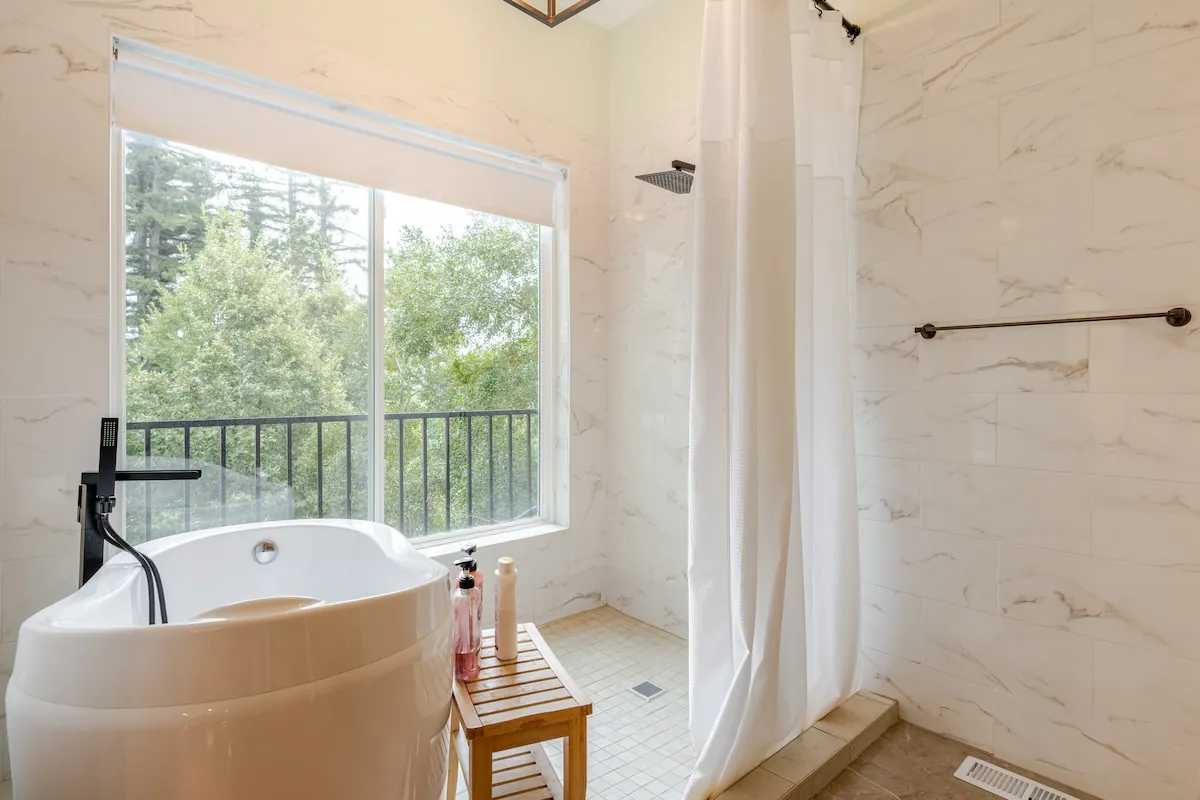 Spa-style bathroom with soaking tub and forest view