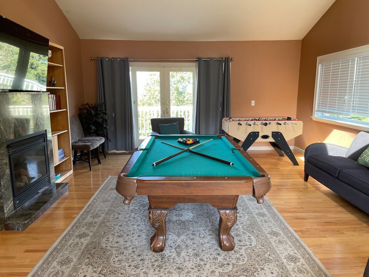 Game room with pool table, foosball, fireplace, and TV at The Crow's Nest Retreat